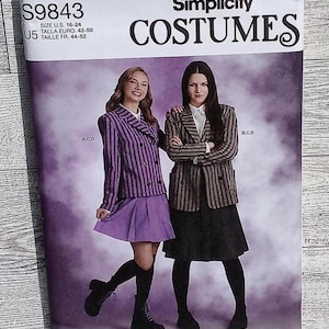 May include: Simplicity Costumes sewing pattern S9843 for sizes 16-24. The envelope features two individuals wearing double-breasted blazers with striped patterns, paired with skirts and black boots against a purple, cloudy background.