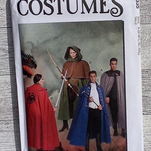 May include: McCall's Costumes sewing pattern featuring medieval and fantasy costume designs. The pattern includes capes, cloaks, and hooded garments in various colors. The image shows illustrations of the finished costumes, with the text "COSTUMES" prominently displayed.