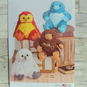 May include: A Simplicity sewing pattern for making four plush toys. The pattern is for a brown owl, a blue platypus, a brown platypus, and a white owl. The pattern is labeled S9423 OS and is designed and printed in the USA.