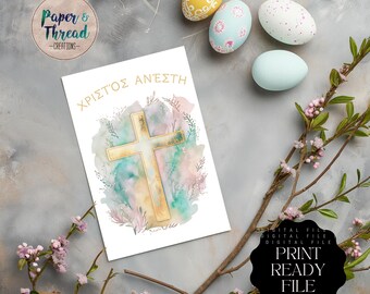 May include: A printable digital file featuring a gold cross with a watercolor background. The text "ΧΡΙΣΤΟΣ ΑΝΕΣΤΗ" is written in Greek at the top of the card. The card is surrounded by Easter eggs and spring flowers.