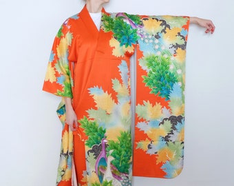May include: A vibrant orange kimono with a floral pattern featuring peacocks and leaves in shades of green, blue, and yellow.
