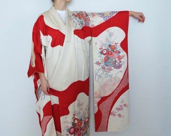 May include: A white and red Japanese kimono with floral embroidery. The kimono has a large red design on the front and a smaller floral design on the sleeve.