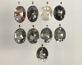 Pode incluir: Nove diamantes pretos ovais, facetados, com inclusões. Os diamantes estão dispostos em três filas, com três diamantes em cada fila. Os diamantes são numerados de 1 a 9.