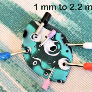 May include: Assortment of colourful heat shrink tubing in various sizes, ranging from 1 mm to 2.2 mm in diameter. The tubing is shown on a green and black patterned surface.