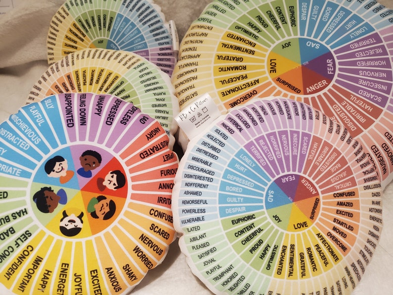 Peut inclure: Un ensemble d'oreillers ronds et color&eacute;s avec une roue des &eacute;motions imprim&eacute;e sur chacun. Les &eacute;motions sont organis&eacute;es en cercle avec des couleurs diff&eacute;rentes pour chaque cat&eacute;gorie. Les oreillers sont faits de tissu doux et sont parfaits pour se blottir ou m&eacute;diter.