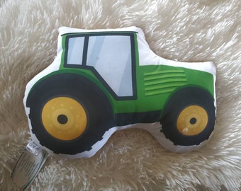 Könnte beinhalten: Ein grünes und gelbes Kissen in Form eines Traktors. Das Kissen ist aus weichem Stoff und hat einen weißen Hintergrund.