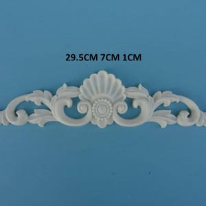 May include: White decorative trim with a floral design, measuring 29.5 inches long, 7 inches wide, and 1 inch thick.