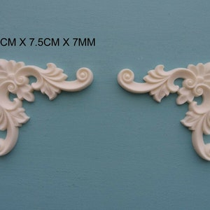 Puede incluir: Dos molduras de esquina blancas y ornamentadas con un diseño floral. Cada moldura mide 7,5 cm por 7,5 cm por 7 mm.