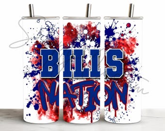 May include: A cylindrical stainless steel tumbler with a lid and straw, featuring a white background with red and blue paint splatter patterns. The text "BILLS NATION" is printed in large blue block letters and blue graffiti-style script.
