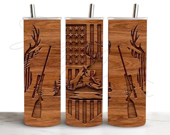 May include: A cylindrical tumbler with a wood grain pattern featuring a graphic of an American flag, a deer with antlers, a rifle, and a mountain landscape. The tumbler includes a silver-colored metal straw inserted into the top lid.