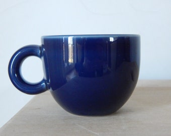 May include: A deep blue ceramic coffee cup with a rounded handle.