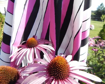 May include: Pink, black, and white striped fabric with pink and white coneflowers in the foreground.