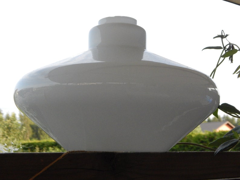 May include: A white glass lampshade shaped like a flying saucer. The lampshade is smooth and has a glossy finish.