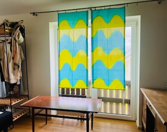 May include: Two rectangular window curtains hanging from a metal rod, featuring a repeating horizontal wave pattern in bright lime green and turquoise blue. The lightweight fabric panels are positioned side by side, covering a glass door.