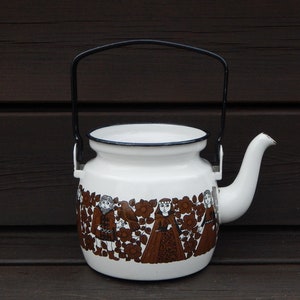 Puede incluir: Tetera de esmalte blanco con asa negra y diseño floral marrón y blanco con personas con ropa tradicional.