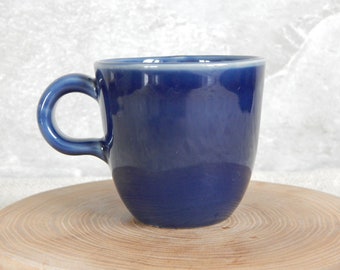 May include: A solid blue ceramic coffee mug with a rounded handle.