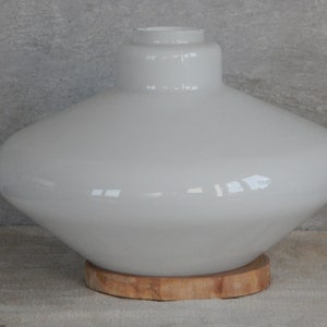 May include: White glass lampshade with a wide, rounded base and a wooden base.