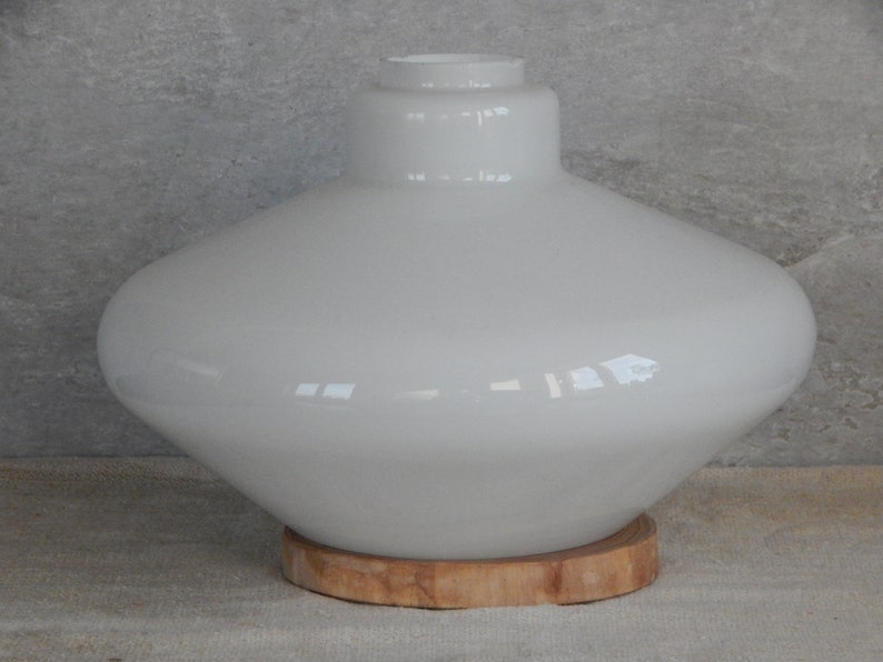 May include: White glass lampshade with a wide, rounded base and a wooden base.