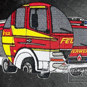 May include: Embroidered patch of a red and yellow fire truck with the word "FEUERWEHR" on the side. The patch is on a black background.