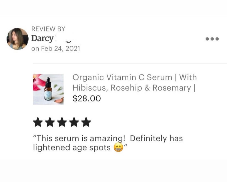 May include: A five-star review for an organic vitamin C serum with hibiscus, rosehip, and rosemary. The serum is in a clear glass bottle with a dropper. The review states "This serum is amazing! Definitely has lightened age spots."