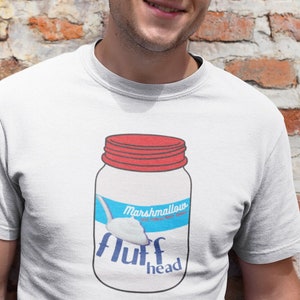 May include: White t-shirt with a graphic of a jar of marshmallow fluff with the text "Marshmallow Fluff" and "Fluff Head" on it.