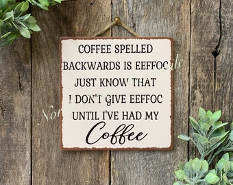 May include: A rustic metal sign with a white background and brown lettering. The sign reads "Coffee spelled backwards is eefficoc. Just know that I don't give eefficoc until I've had my Coffee."