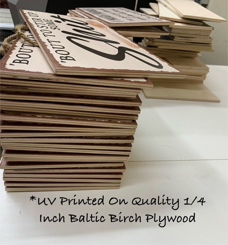 May include: A stack of wooden signs with a distressed look. The signs have a light background with black text and a brown border. The text on the sign says "BOUT TO STIR UP SOME". The signs are made of 1/4 inch Baltic Birch Plywood.