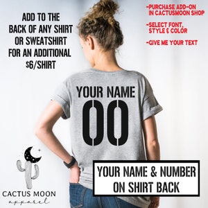 May include: A gray t-shirt with "YOUR NAME 00" printed on the back. The text "YOUR NAME & NUMBER ON SHIRT BACK" is printed below the number. The text "ADD TO THE BACK OF ANY SHIRT OR SWEATSHIRT FOR AN ADDITIONAL $6/SHIRT" is printed on the left side of the image. The text "PURCHASE ADD-ON IN CACTUSMOON SHOP", "SELECT FONT, STYLE & COLOR", and "GIVE ME YOUR TEXT" is printed on the right side of the image.