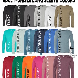May include: A variety of long-sleeved shirts in different colors, including black, teal, red, kelly green, orange, berry, heather navy, heather dusty blue, heather deep teal, heather mauve, heather slate, heather olive, athletic heather, white, and asphalt. The shirts are arranged in three rows, with the colors of each row changing from left to right.