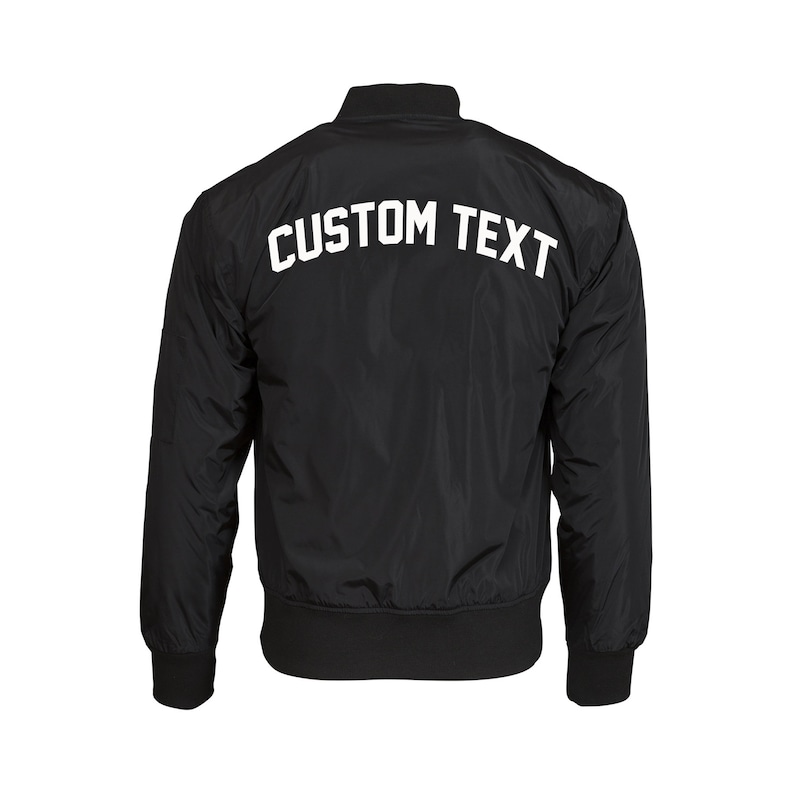 Puede incluir: Chaqueta bomber negra con "CUSTOM TEXT" en blanco en la espalda.