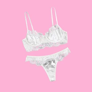 May include: White lace lingerie set with a satin bra and matching panty. The panty has the initials "W & S" embroidered on the front.