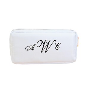 May include: White zippered pouch with a black embroidered monogram "A W & E"
