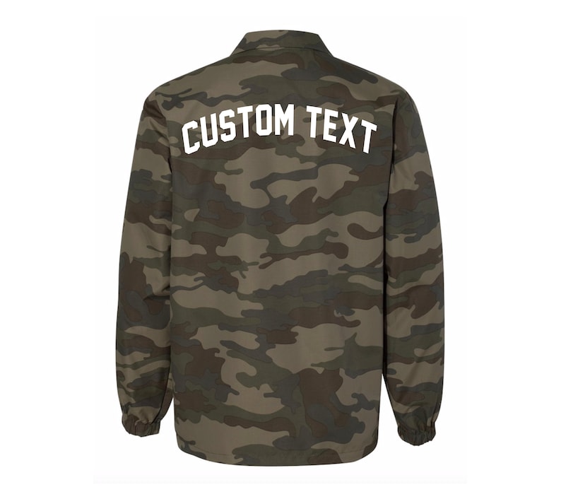May include: A green, brown, and black camouflage jacket with a white "CUSTOM TEXT" on the back.