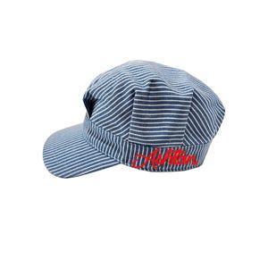 May include: A blue and white striped baseball cap with a red embroidered name "Ayden" on the front.