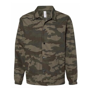 May include: A green, brown, and black camouflage print jacket with a button-up front and a pocket on the left side.