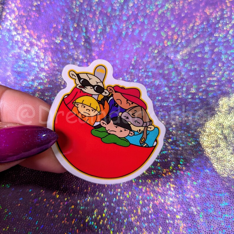 May include: A red and white sticker featuring a group of cartoon characters from the animated series 'The Kids Next Door'. The characters are all wearing different coloured clothing and are sitting in a red bowl.