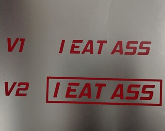 May include: Two versions of a red vinyl sticker with the text "I EAT ASS". The first version is plain text, while the second version is enclosed in a red rectangle.