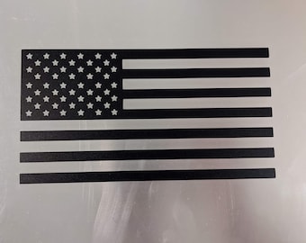 May include: A black and white American flag design. The flag is made of metal and has a distressed look.