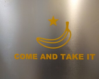 May include: A yellow banana with a star on top and the text "COME AND TAKE IT" on a silver background.