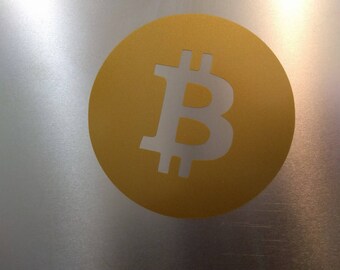 May include: A gold circle with a white Bitcoin symbol in the center.