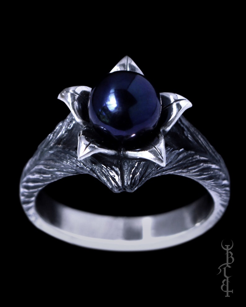 sterling silver ring with a rustic, textured ring band, with a black pearl on top with 5 leaves