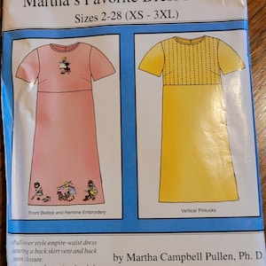 May include: A sewing pattern package titled "Martha's Favorite Dress Pattern" with sizes XS-3XL. The package features illustrations of two dress designs: a pink dress with embroidery and a yellow dress with vertical pintucks. The text "Sew Beautiful's FREE Gift" is at the top.