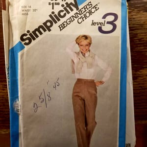 May include: A Simplicity sewing pattern for a level 3 beginner. The pattern is for a pair of pants with a 30 inch waist and is size 16. The pattern features a woman wearing the pants with a white shirt and a scarf.