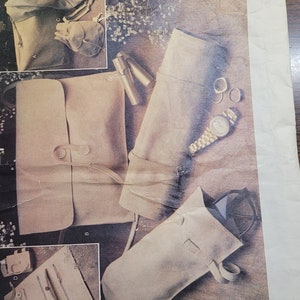 May include: A vintage Vogue Patterns sewing pattern for a set of leather accessories. The pattern is for a small bag, a wristlet, a glasses case, and a makeup bag. The pattern number is 1703 and the price is $3.00.