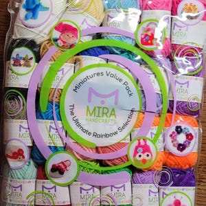 May include: A clear plastic bag containing a selection of colourful yarn skeins. The yarn is arranged in rows and columns, with shades of pink, blue, green, and purple. The packaging features the text "MIRA HANDCRAFTS" and "Miniatures Value Pack".