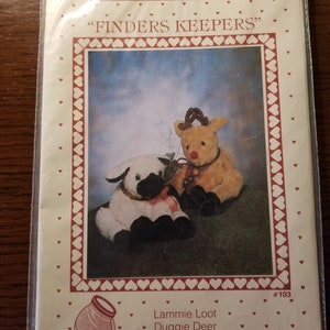 May include: A craft pattern for making two plush toys, a white lamb named Lammie Loot and a brown reindeer named Duggie Deer. The pattern is titled "Finders Keepers" and is number #103.