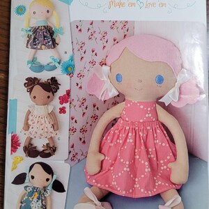 May include: A sewing pattern for making whimsical dolls. The pattern includes four different doll designs, each with a unique dress and hair style. The pattern is titled "Bit of Whimsy Dolls" and includes the text "Make 'em Love 'em".