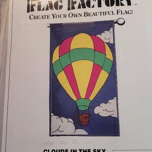 May include: A craft pattern for a hot air balloon flag. The pattern includes instructions for a flag measuring 28 inches by 49 inches. The pattern is titled "Clouds in the Sky" and is from The Flag Factory.