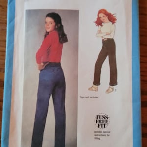 May include: Simplicity sewing pattern number 9089 for pants. The pattern includes instructions for a fuss-free fit. The pattern shows two models wearing the pants, one in blue denim and one in brown.