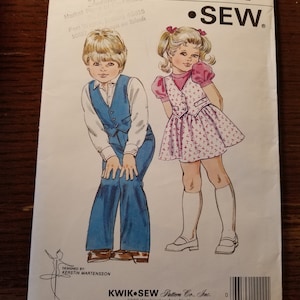 May include: A sewing pattern for children's clothing. The pattern is for sizes T1-T2-T3-T4. The pattern is called "KWIK-SEW" and the pattern number is 1300. The pattern shows a boy and a girl wearing the clothing. The boy is wearing a blue shirt, a blue vest, and blue pants. The girl is wearing a pink dress with a white vest. The pattern is designed by Kerstin Martensson.